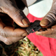 Prisca Korein, a 62-year-old traditional surgeon, holds razor blades before carrying out female genital mutilation on teenage girls from the Sebei tribe northeast of Kampala, Uganda.